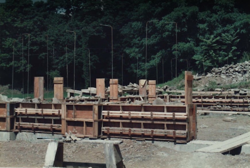 Foundation perimeter established — fieldstone walls at grade